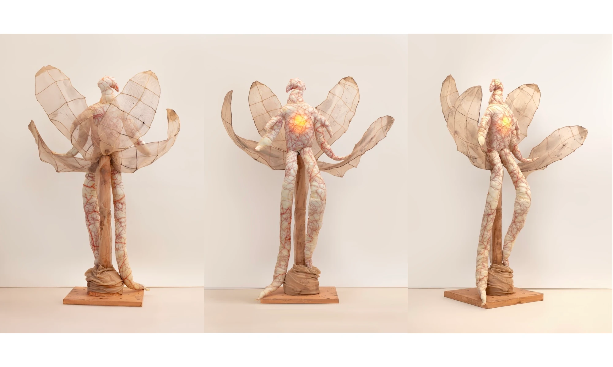 A winged latex figure with a glowing chest, seen from three angles